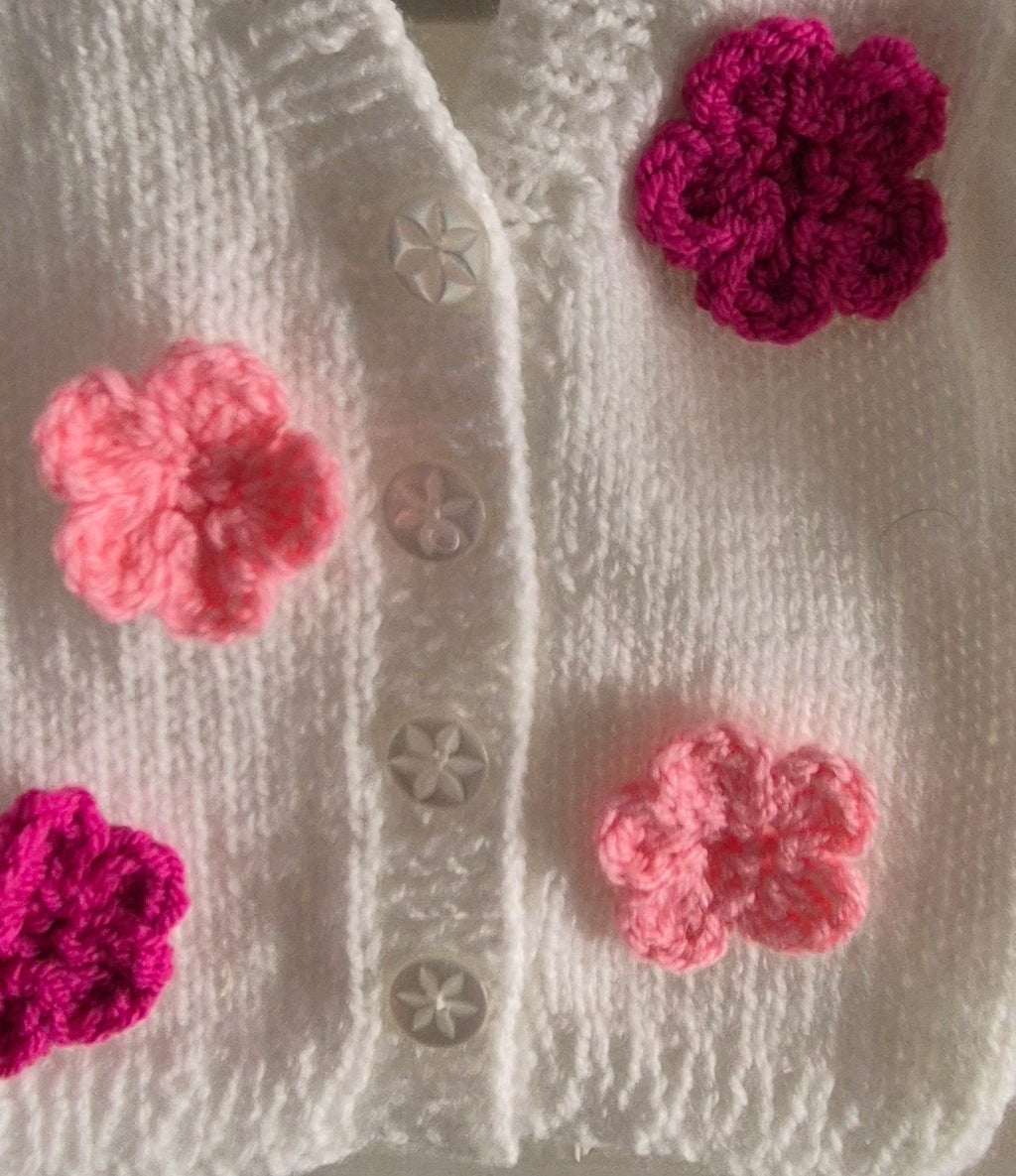 Knitted white cardigan, adorned with crochet flowers