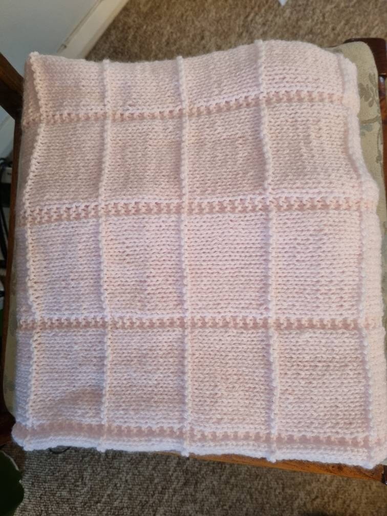 Hand knitted pastel pink baby blanket
