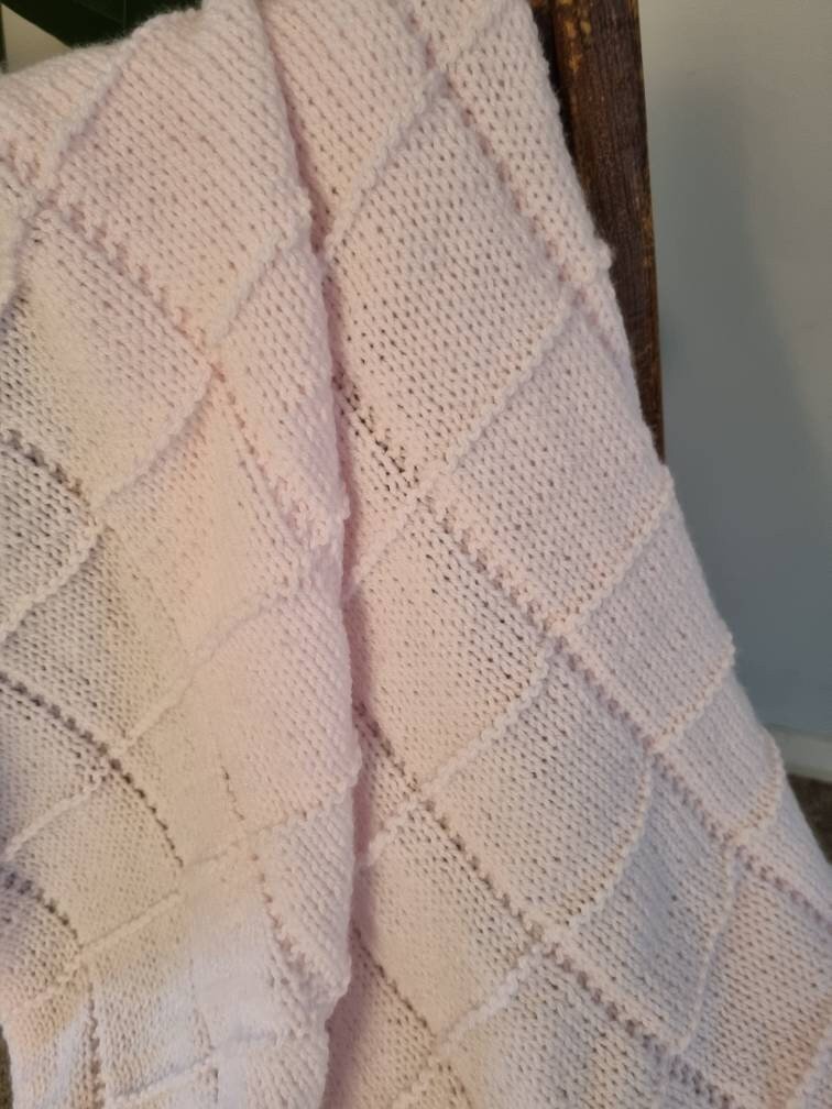 Hand knitted pastel pink baby blanket