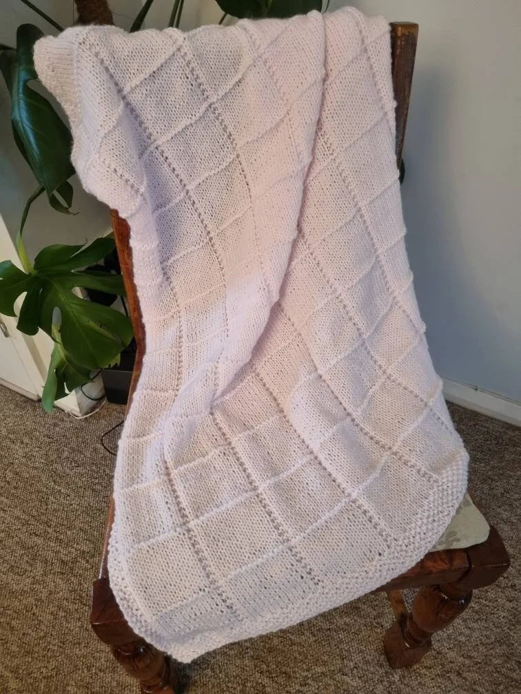 Hand knitted pastel pink baby blanket