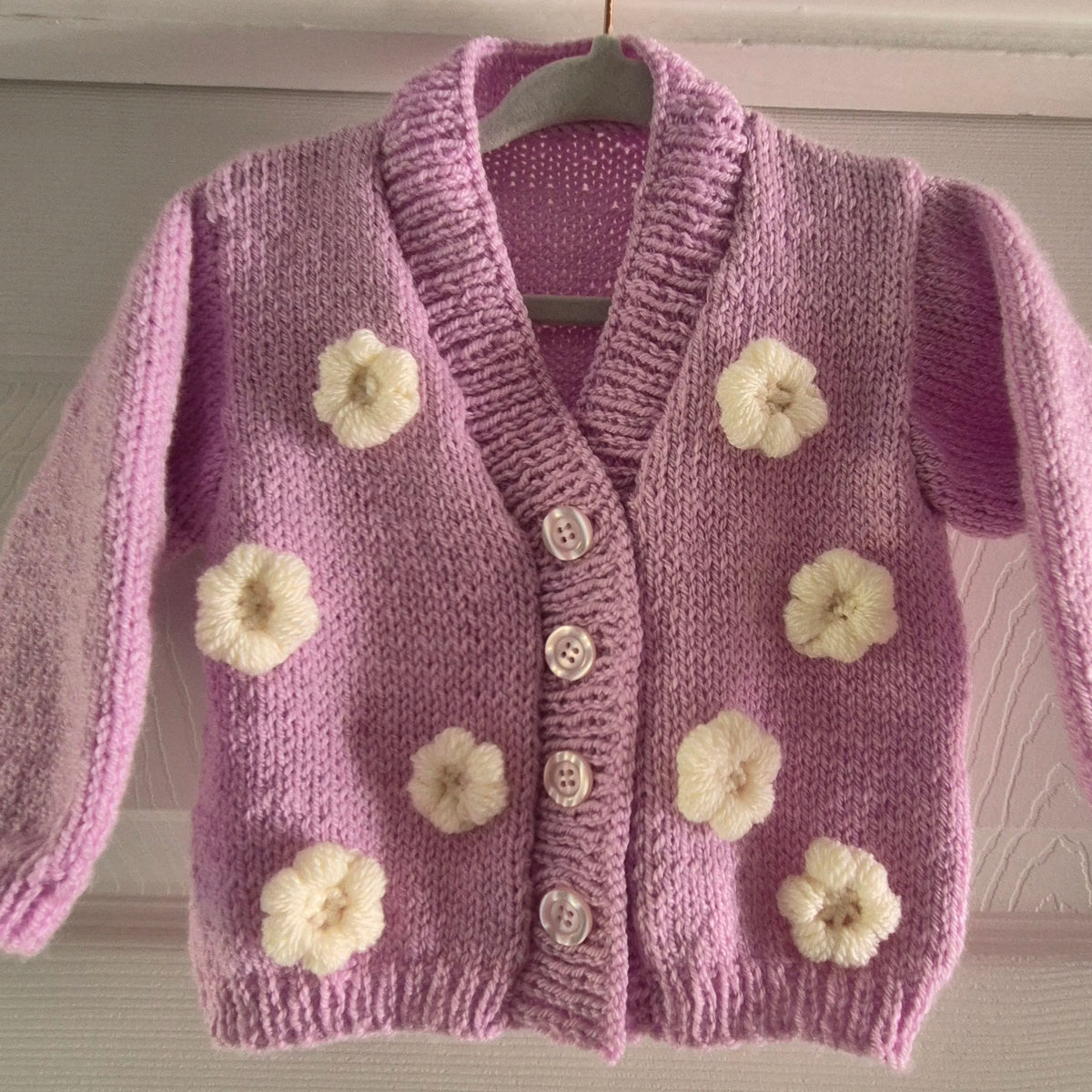 Pink cardigan with crochet flowers